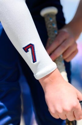 custom numbered arm sleeve shown on a baseball player who is holding a bat